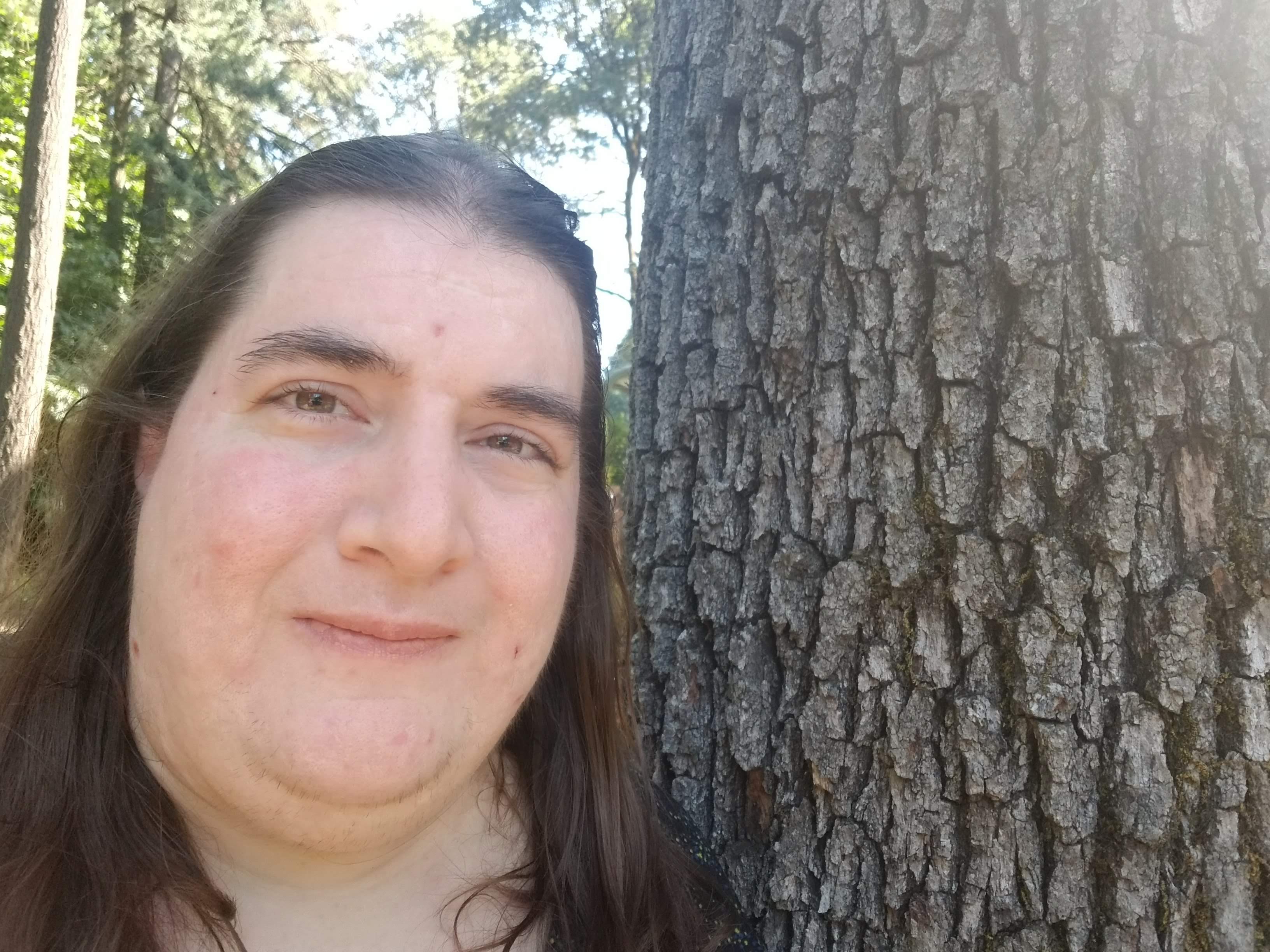 a headshot of me next to a tree in the spring